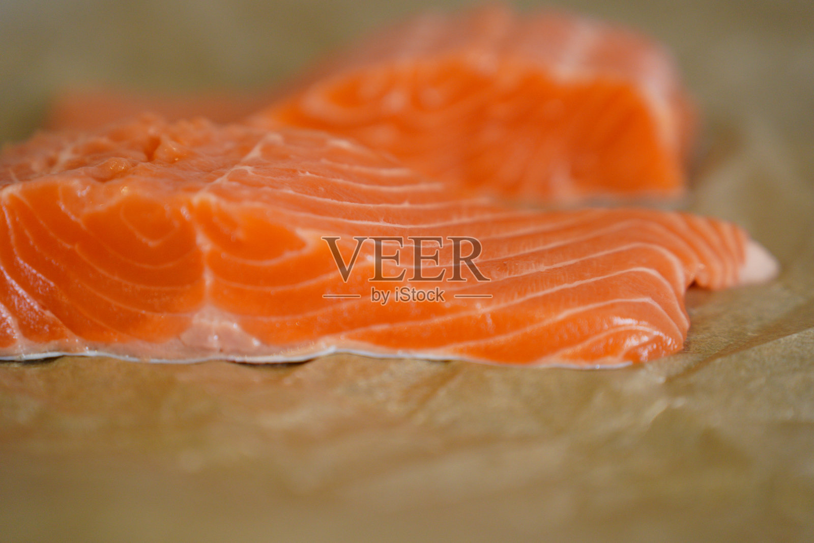 新鲜生三文鱼片放在烘焙纸上照片摄影图片