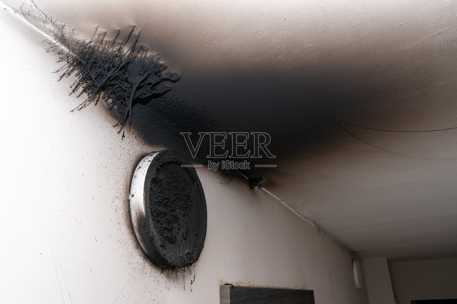 烧毁的LED灯。墙上的灯罩灯在火灾后。住宅建筑中的自燃和火灾。照片摄影图片