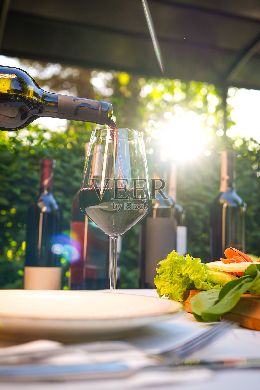 户外优雅餐饮布置下的日落倒酒照片摄影图片