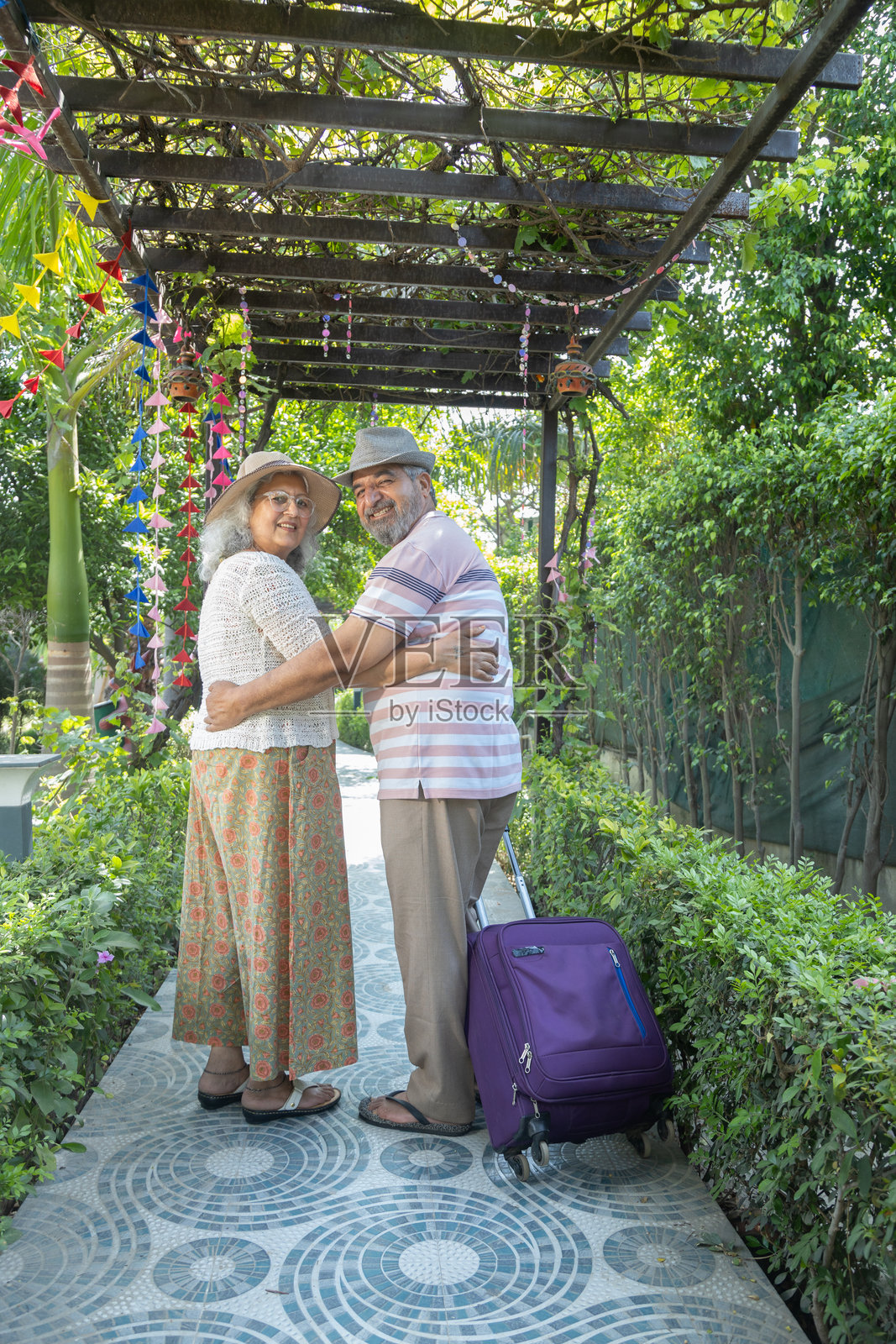 退休的印度老年游客夫妇带着行李箱一起享受夏季假期，快乐的成熟夫妻在度假村度假，老年印度人旅游与旅行，退休生活。照片摄影图片