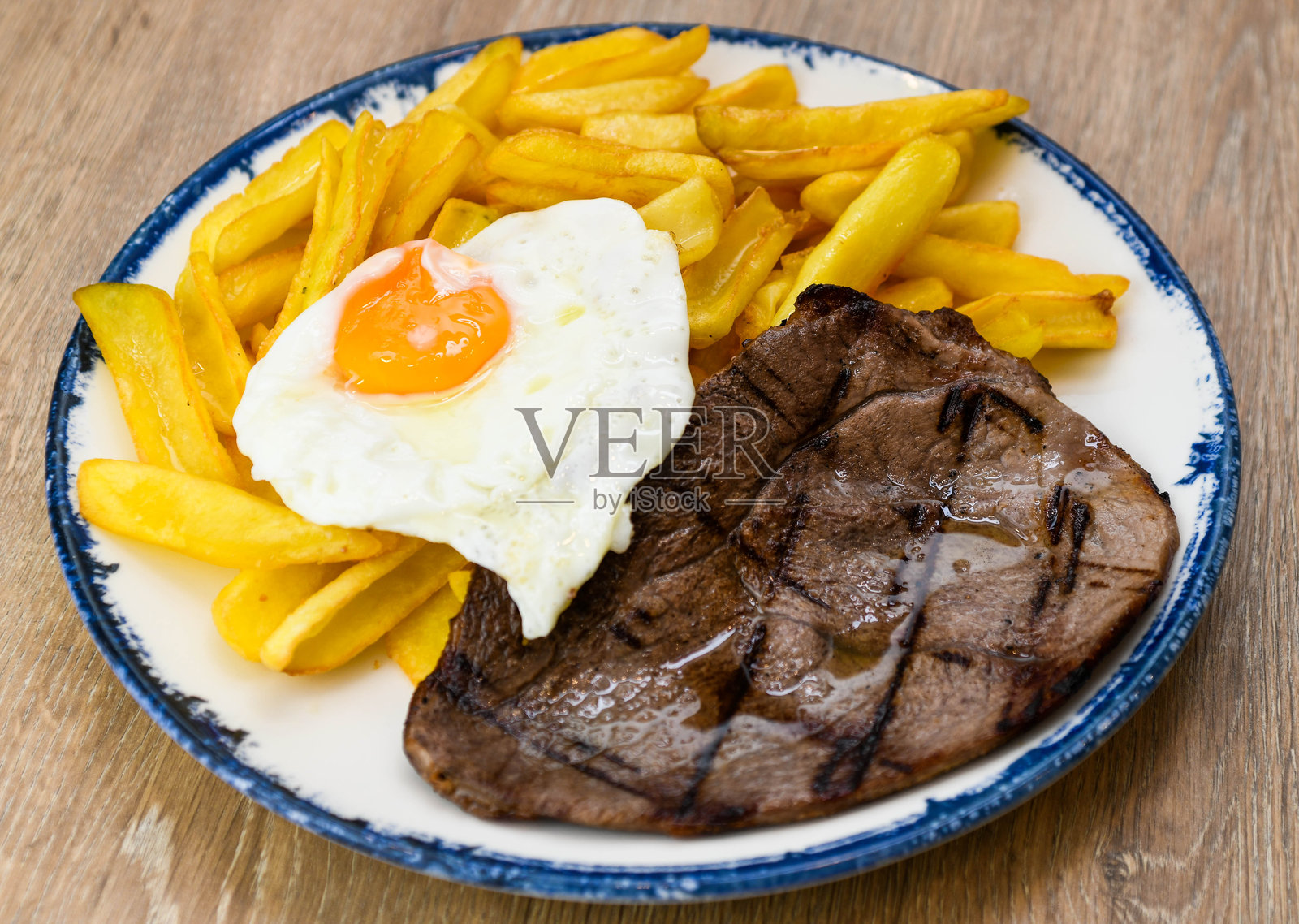 盘子里的牛排配煎蛋和薯条照片摄影图片