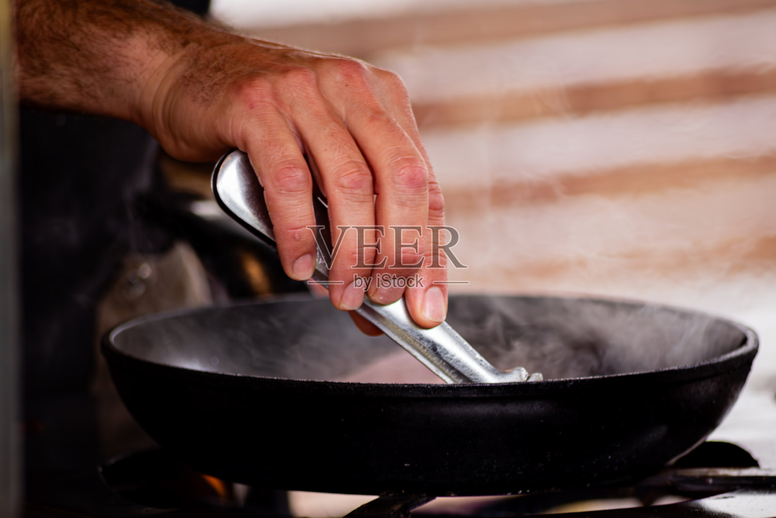 厨师在铸铁锅中煎炸脆皮培根照片摄影图片