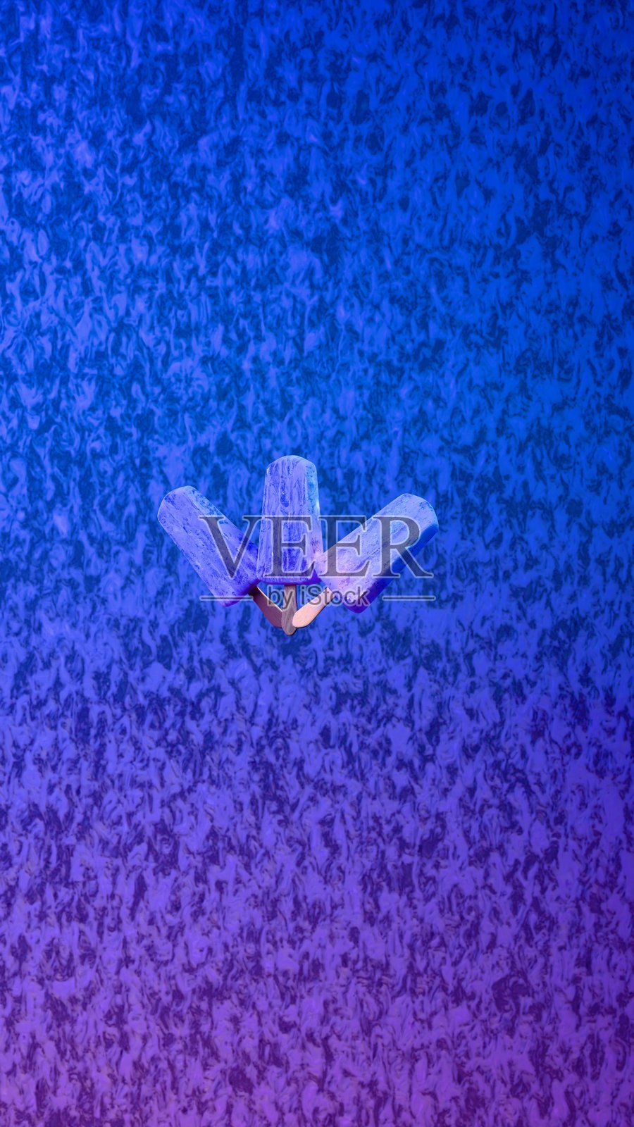 三根蓝色冰棒放在有纹理的蓝紫色背景上照片摄影图片