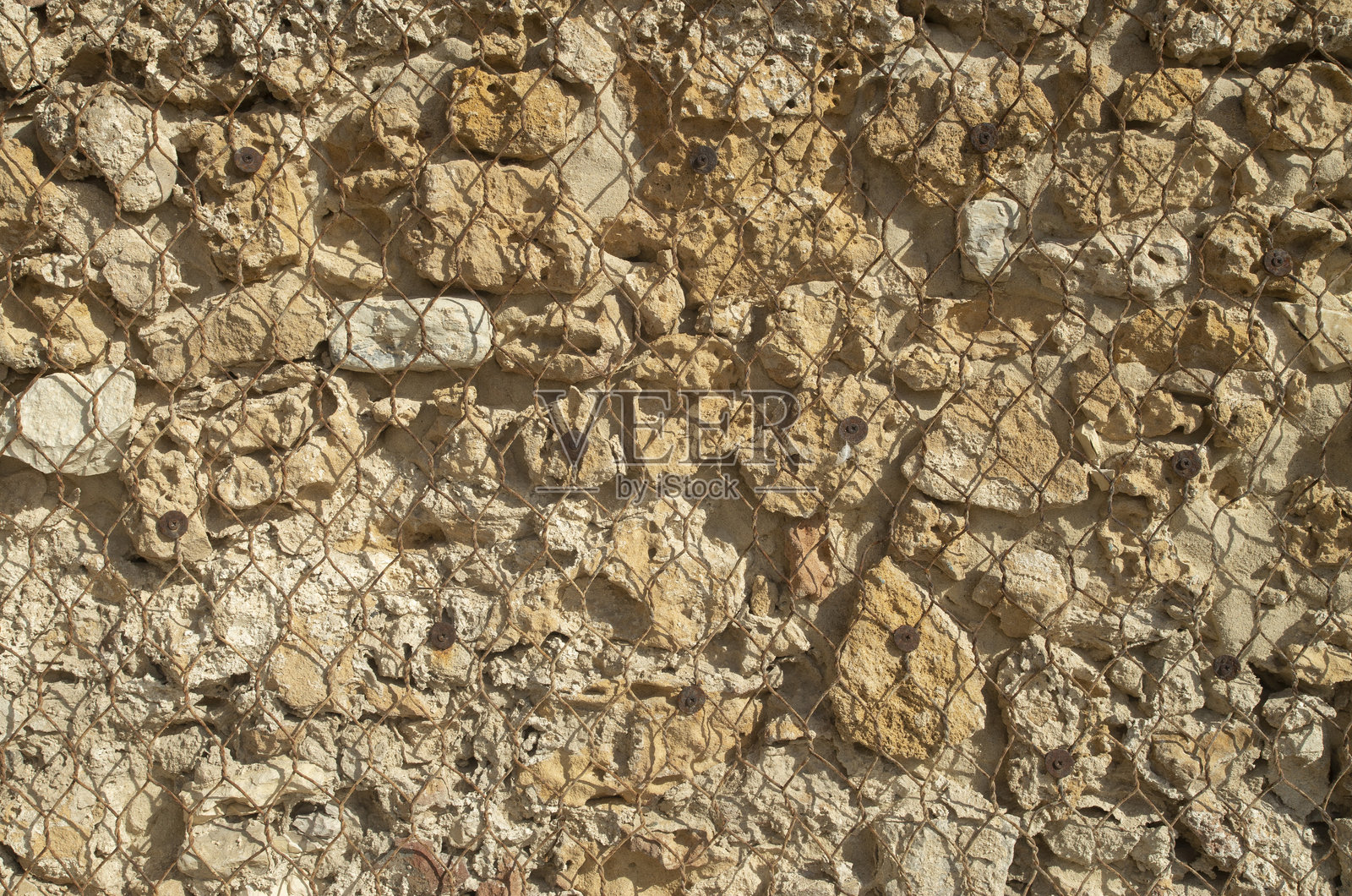 古老的彩色砂岩墙壁，近距离展示了锈蚀的金属网格。照片摄影图片