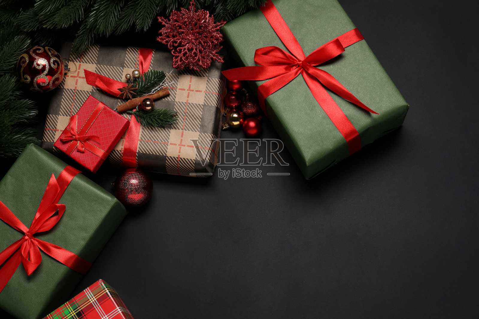 黑色背景上的圣诞装饰和礼品盒，平铺展示。留有文本空间。照片摄影图片