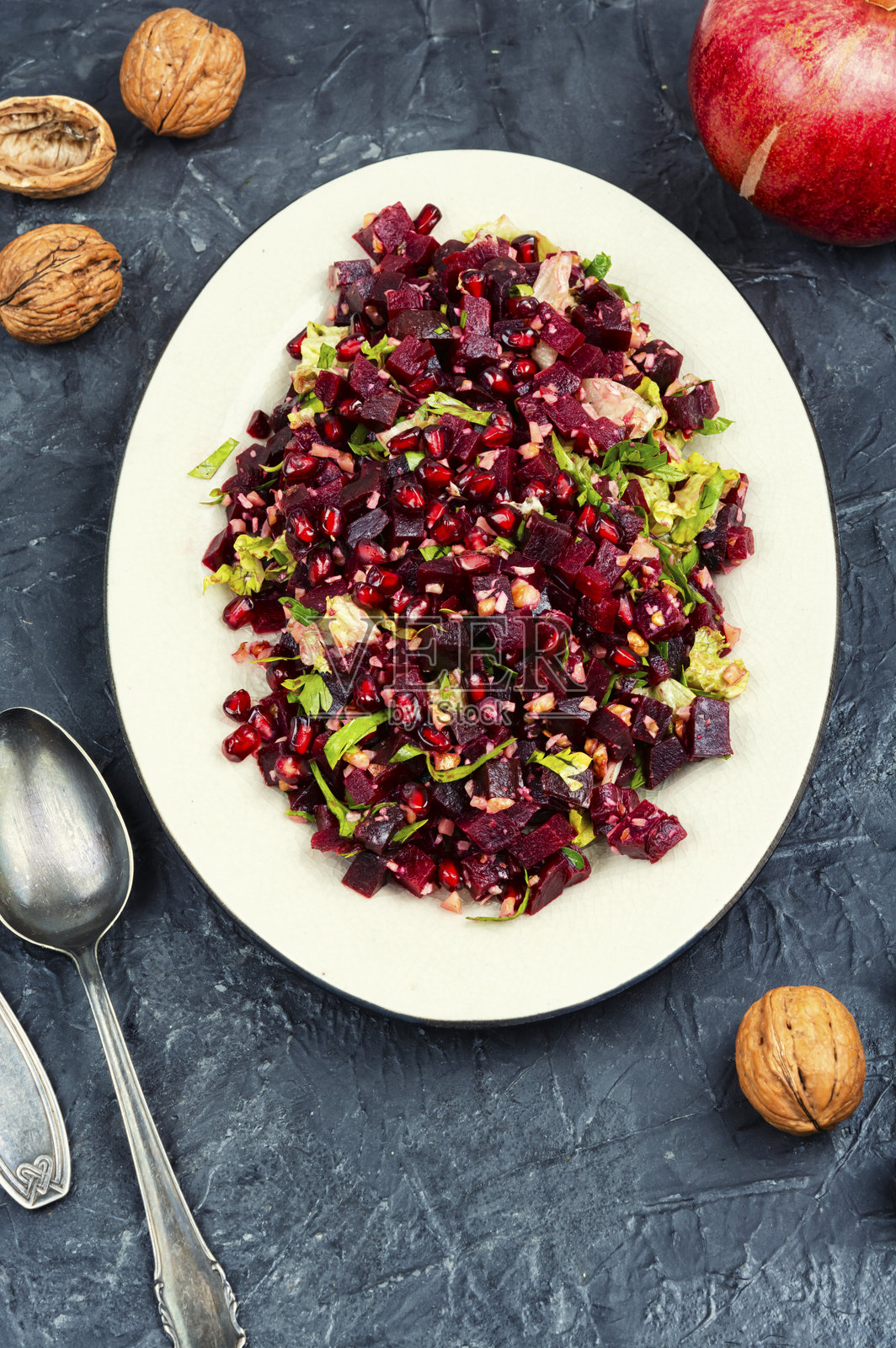 健康沙拉 - 煮熟的甜菜根与石榴。照片摄影图片