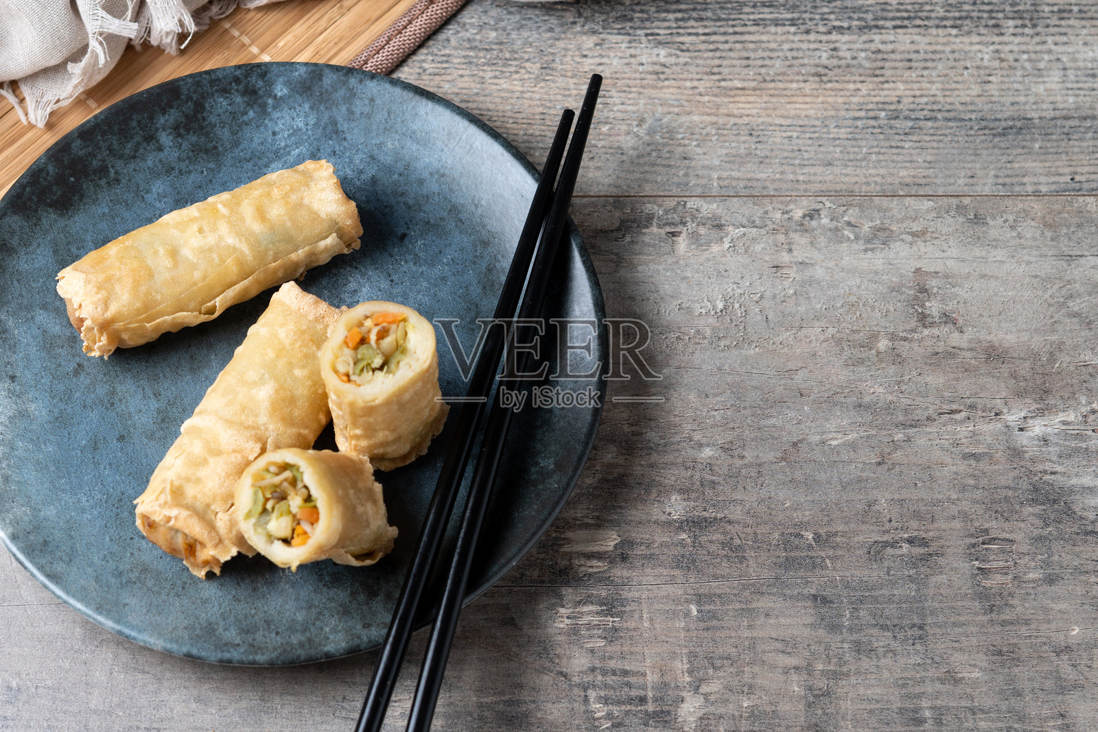 陶瓷盘上的脆春卷放在木桌上照片摄影图片