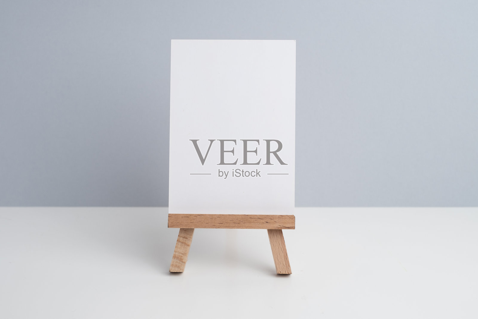 画架和混凝土花盆，上面有一朵花，背景为彩色。照片摄影图片