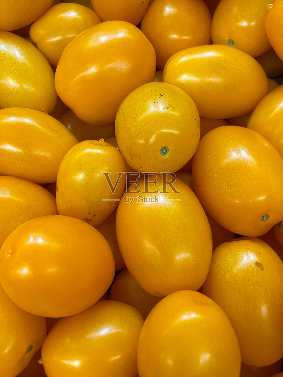 多汁的黄色李子番茄。新鲜市场背景特写。照片摄影图片