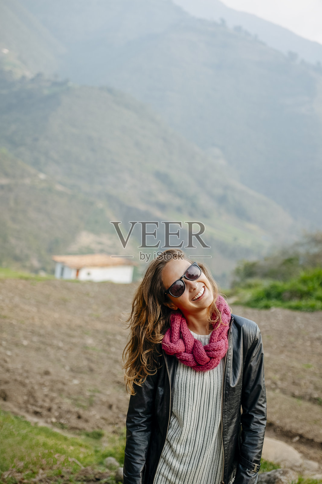 年轻女性在阳光明媚的山景中微笑照片摄影图片