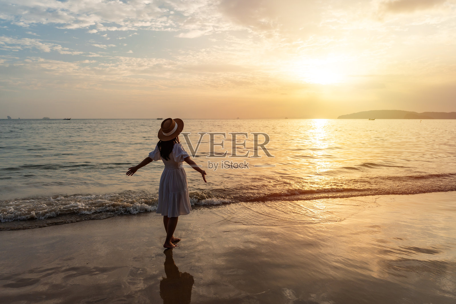 年轻的亚洲女性旅行者在宁静的海滩上享受美丽的日落，夏季假期旅行的概念照片摄影图片