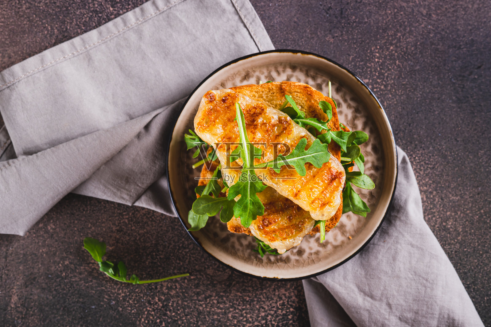 美味的三明治特写，盘子里放着炸哈罗米奶酪和芝麻菜，桌面俯视图照片摄影图片