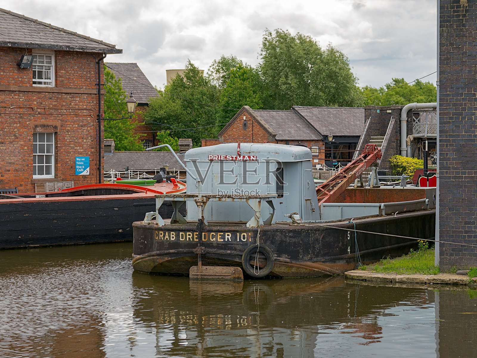 国家水道博物馆。历史悠久的蟹捕捞船停靠在一个古雅的运河码头，周围是工业建筑。照片摄影图片