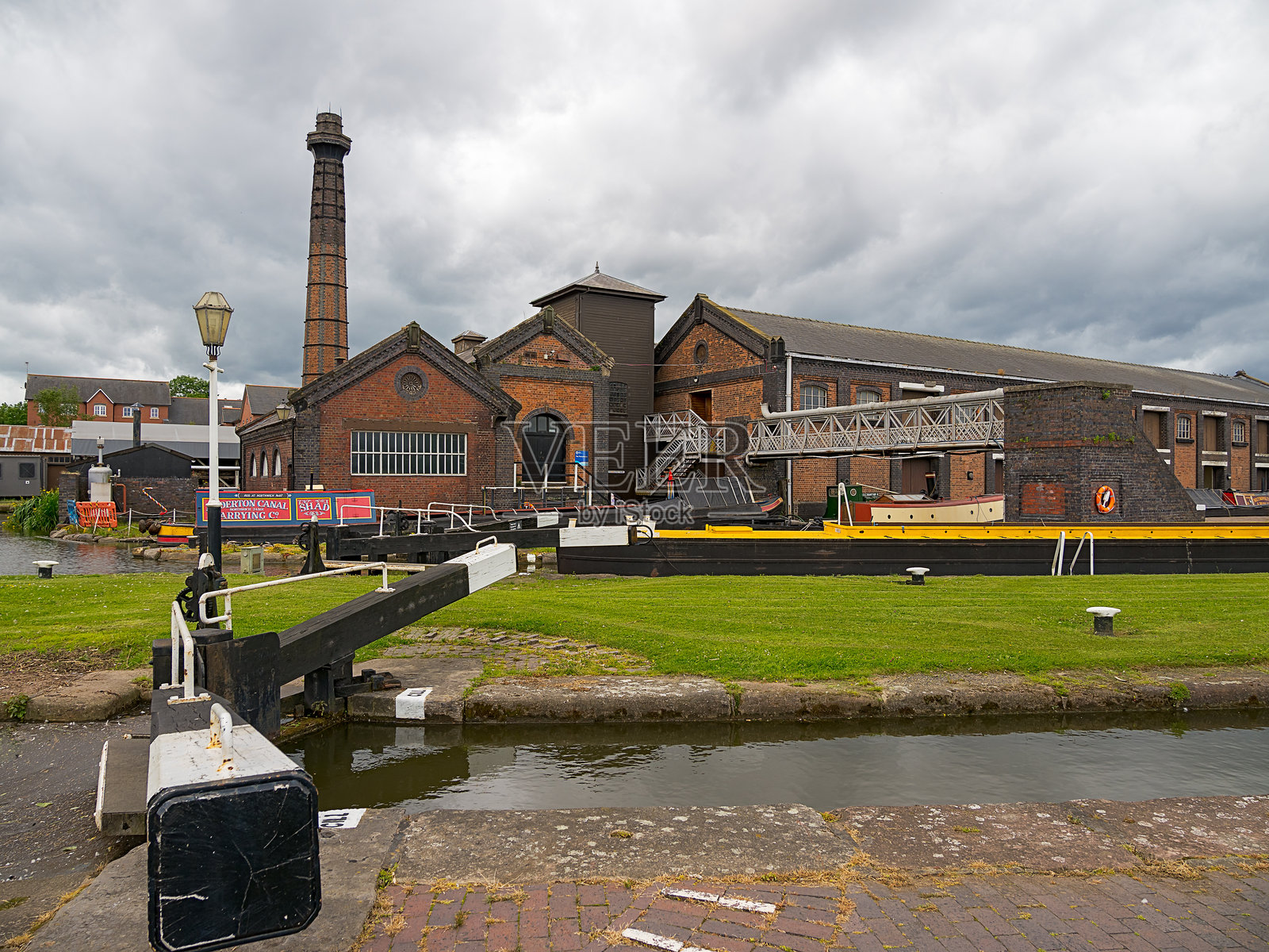 国家水道博物馆。历史悠久的工业建筑与运河闸门在阴 cloudy 的天空下。照片摄影图片