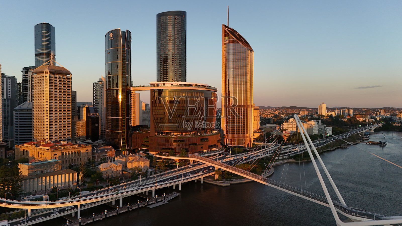 布里斯班中央商务区，昆士兰州，澳大利亚 – 夕阳下的航拍图像，展现城市天际线、高楼大厦、布里斯班河、布里斯班摩天轮和南岸文化区的温暖晚霞。照片摄影图片