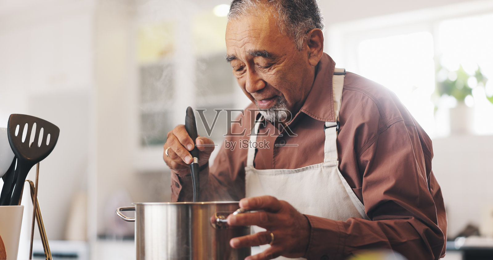 厨房里的成熟男性正在准备晚餐，锅中有菜肴和食谱。厨师、维生素和男性在炉子上烹饪，关注健康、养生和营养。照片摄影图片