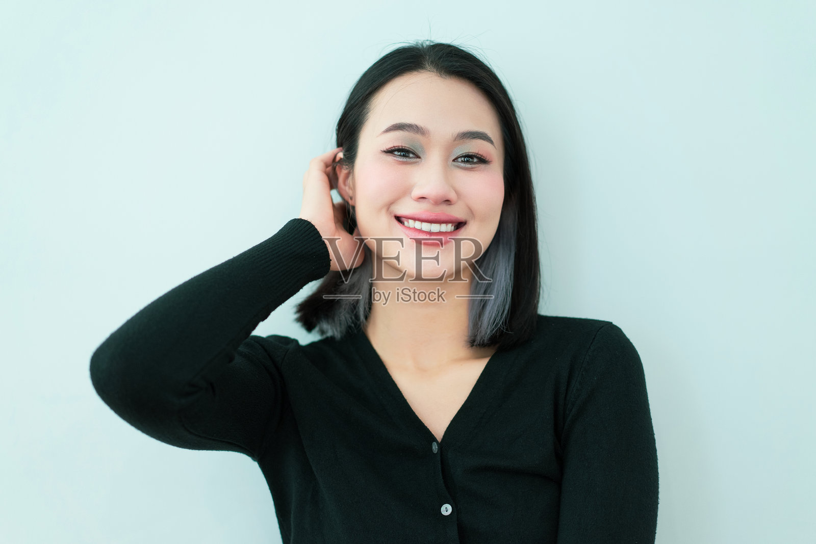 穿着黑色毛衣的微笑女性在明亮背景下表达快乐照片摄影图片