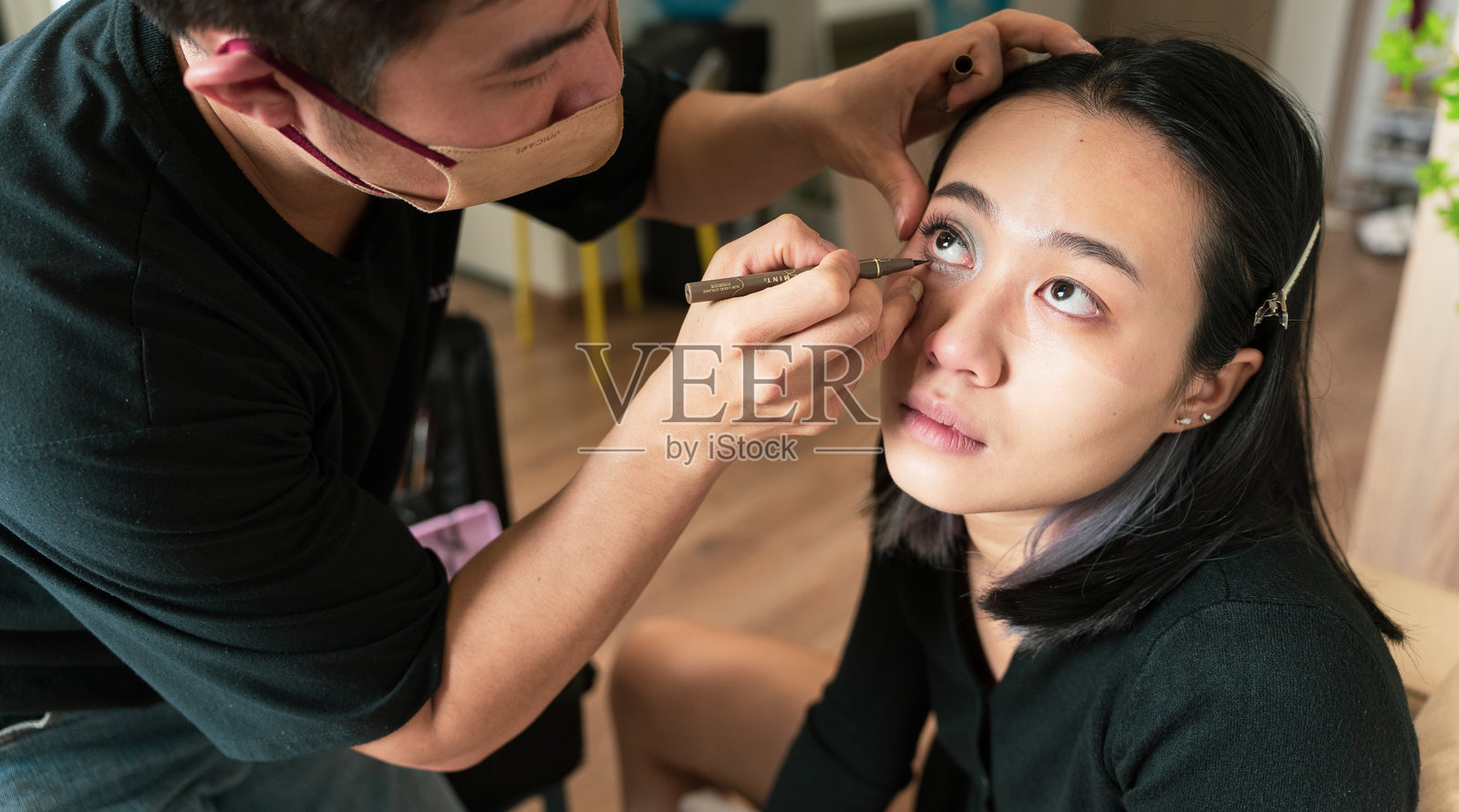 化妆师在工作室为年轻女性化眼妆照片摄影图片