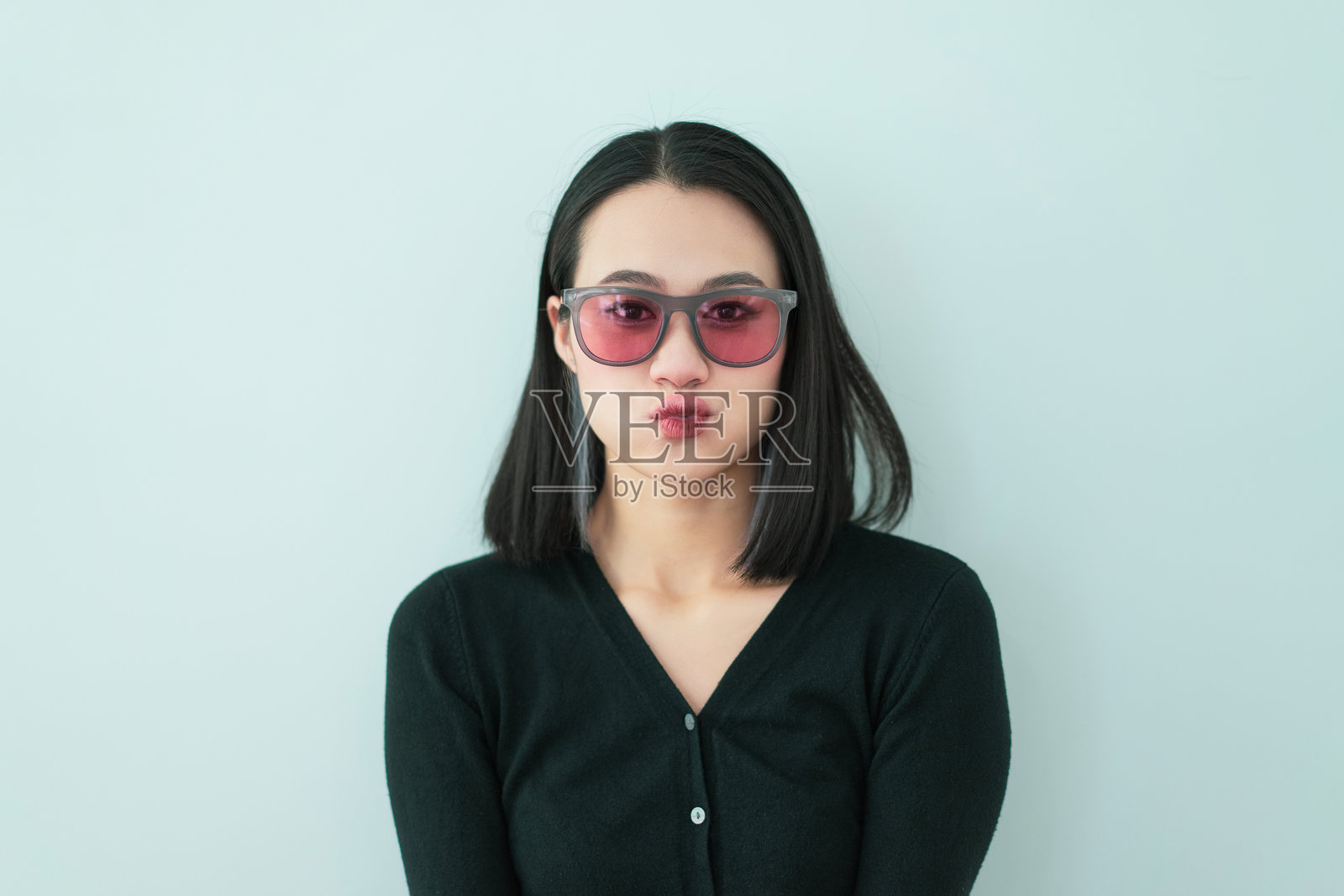 时尚女性佩戴粉色眼镜，展现丰富的面部表情照片摄影图片