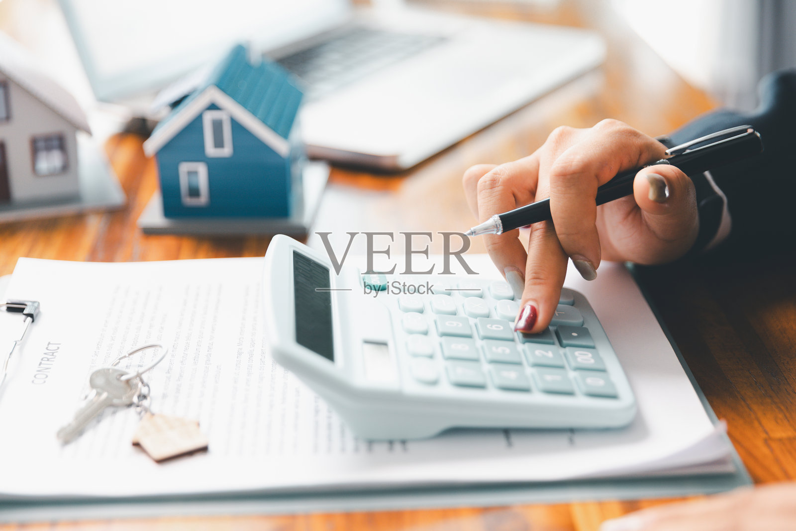 房贷专员使用计算器与房屋计划贷款房地产或物业。重要的是使用贷款计算器寻求房地产、金融保险建议，以确保为业务做出明智的财务决策。照片摄影图片