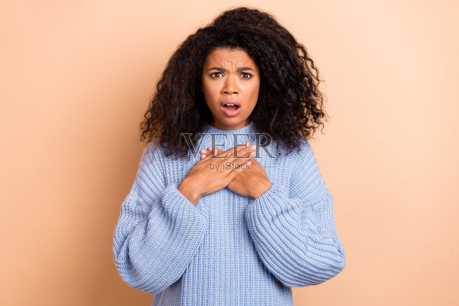 年轻女性因错误而感到害怕、惊慌、孤立，背景为米色。照片摄影图片