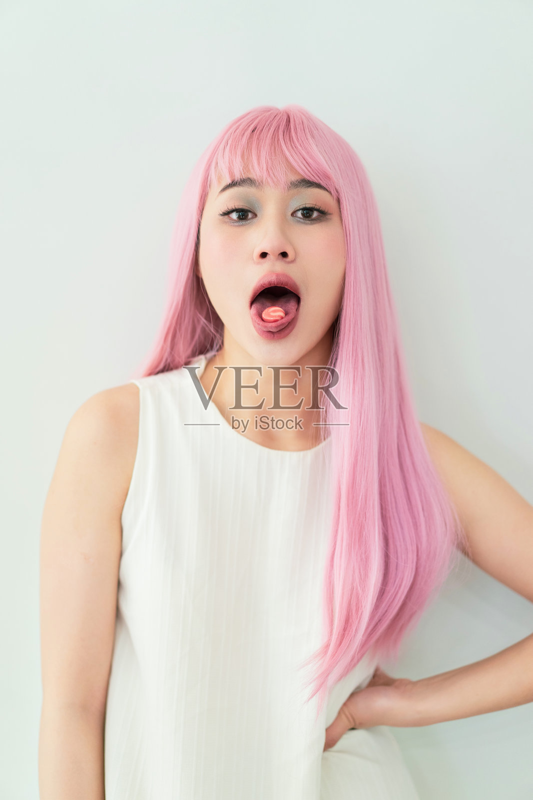 粉发女性调皮地伸出舌头照片摄影图片