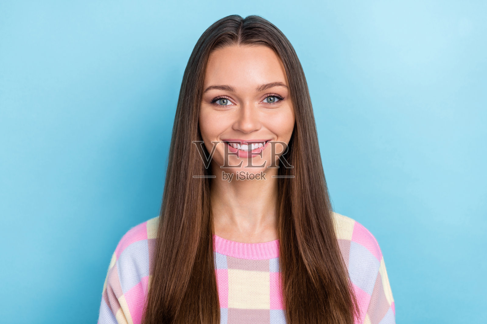 穿着休闲服的可爱女孩，面带灿烂的微笑，背景为蓝色。照片摄影图片