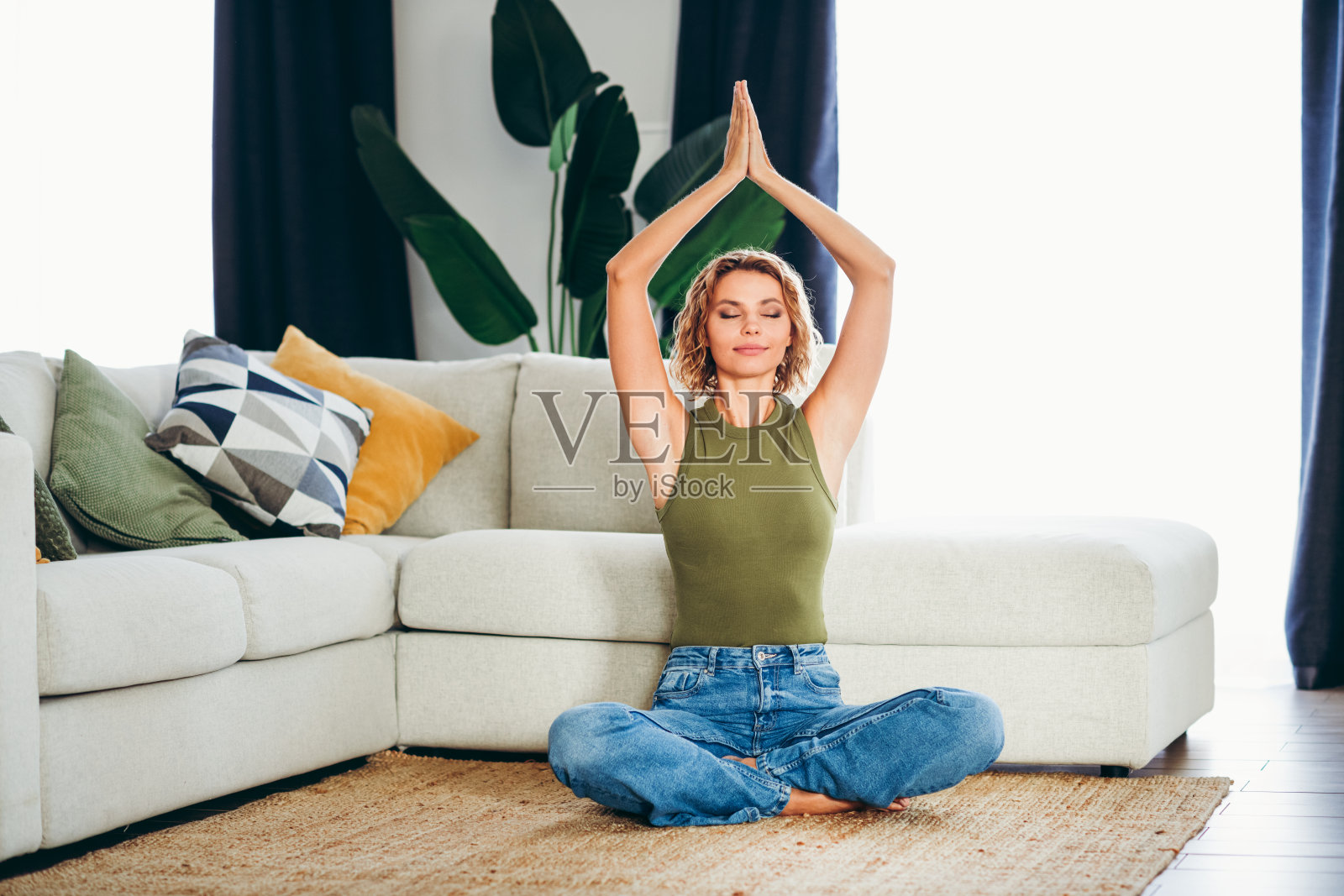 美丽的女性在舒适的客厅环境中练习冥想，以每天拥抱放松和正念。照片摄影图片