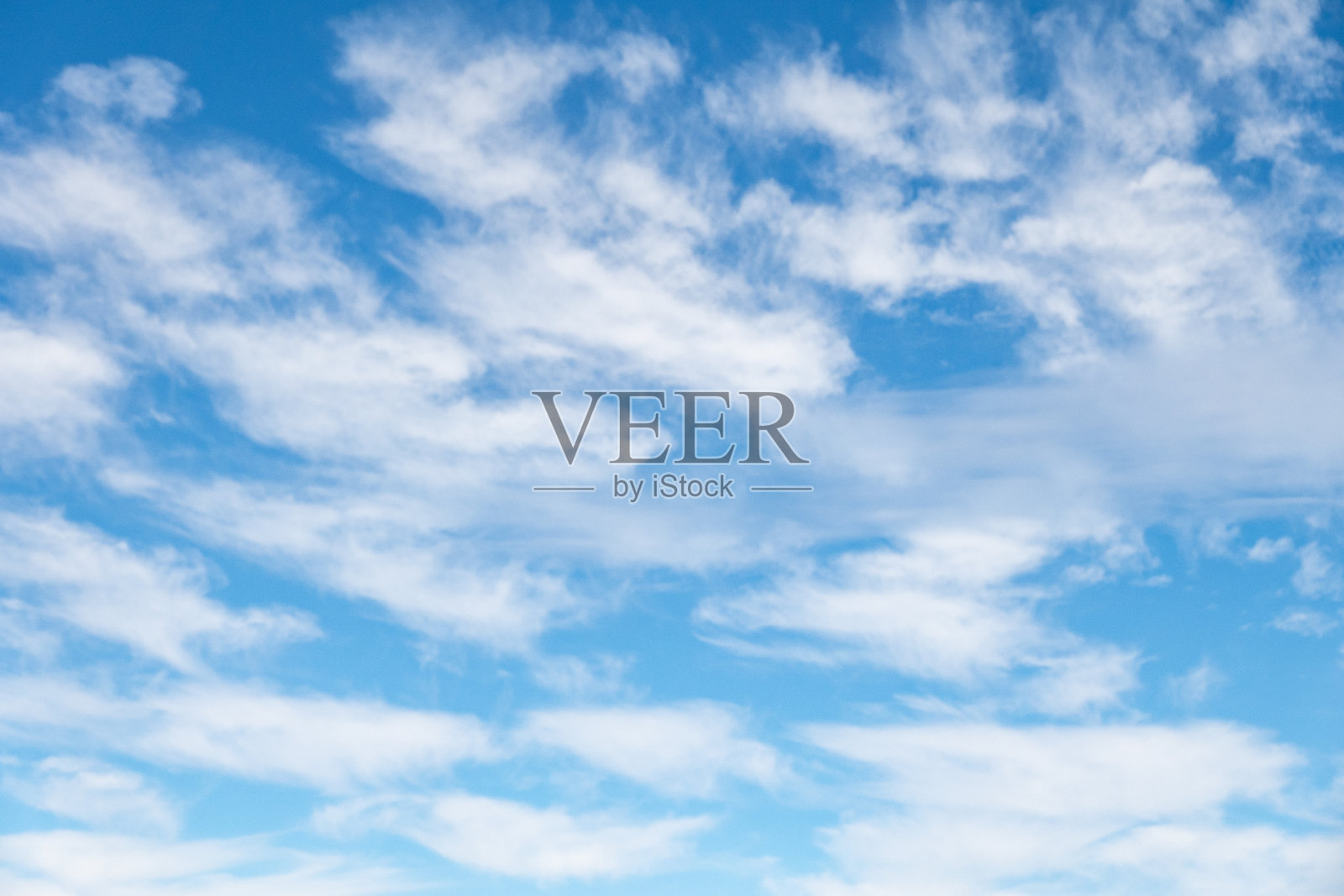 卷云和高积云在蓝天上漂浮，远处是一片山脉。照片摄影图片