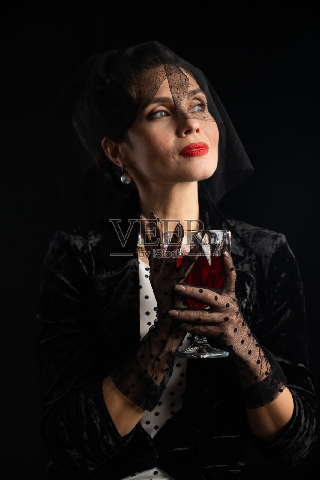 身穿复古服装的优雅女性手持一幅玻璃肖像照片摄影图片