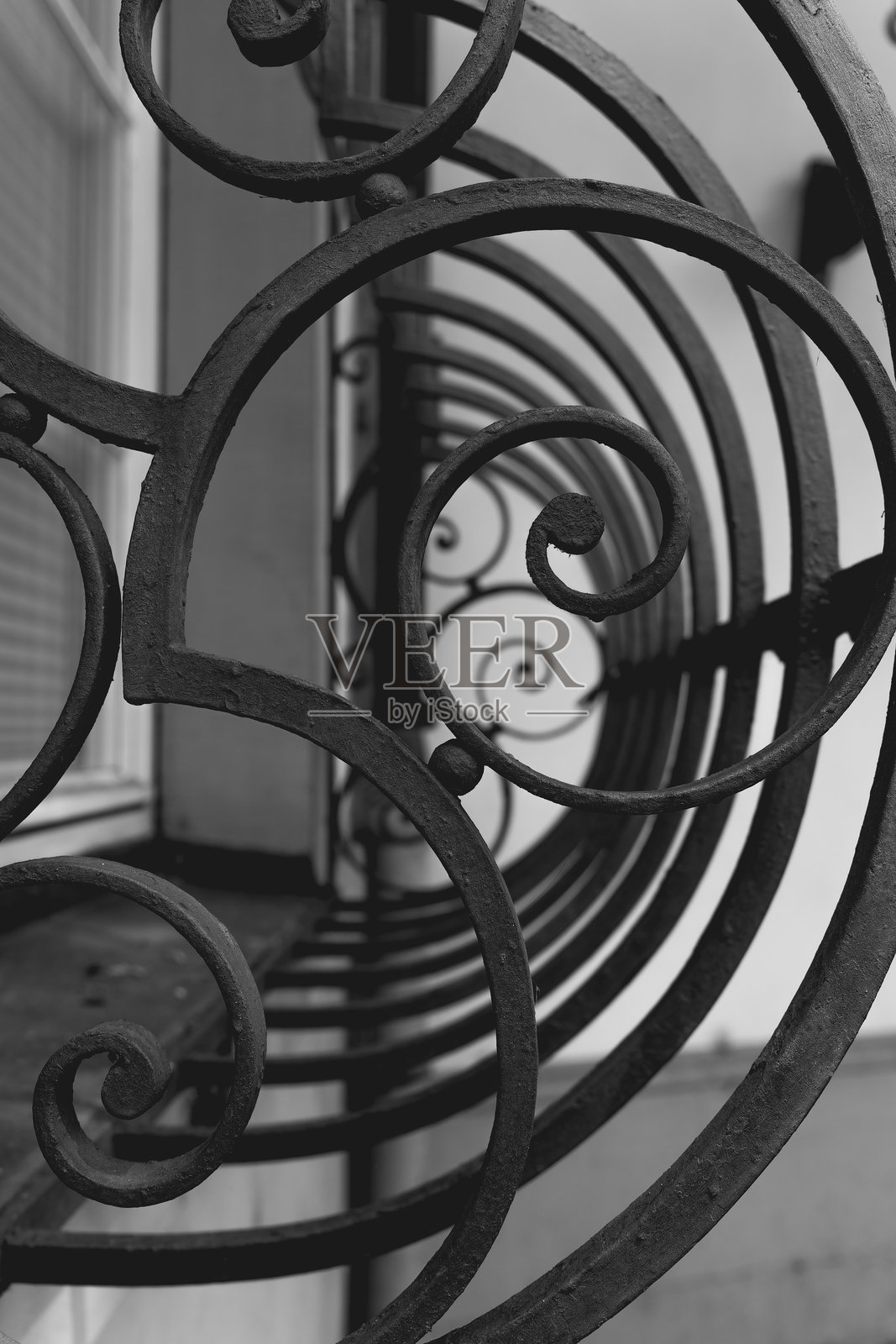 精美的铁艺设计在阳台上优雅地盘旋，俯瞰着傍晚阳光下宁静的城市街道。照片摄影图片