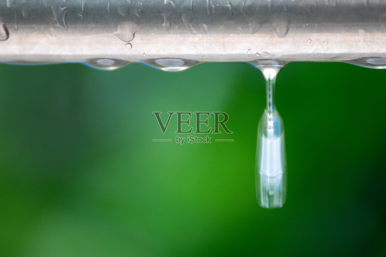 雨水浸湿的金属棒上滴落的水珠照片摄影图片