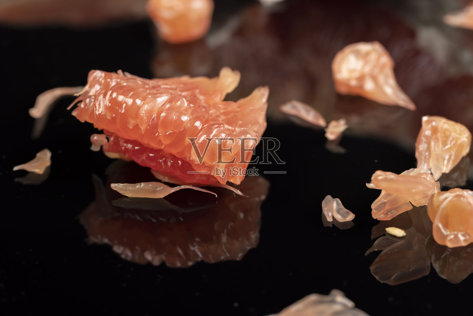 红肉柚子，果实在黑色表面上反射，特写镜头照片摄影图片