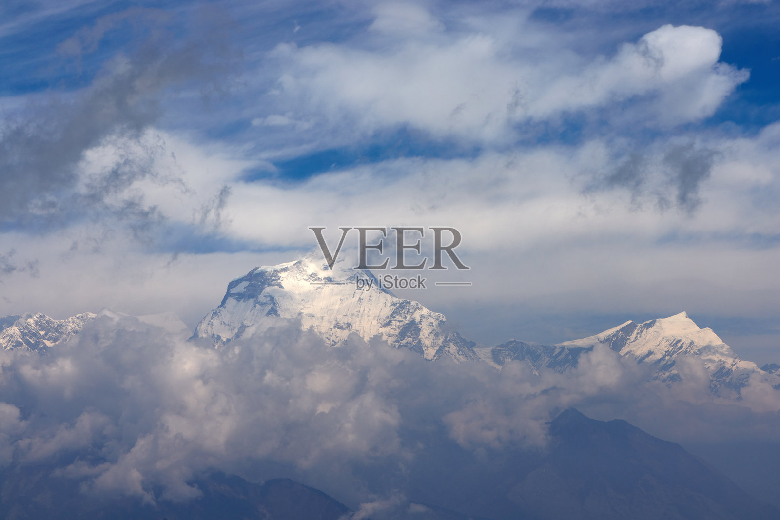 在尼泊尔的安娜普尔纳小径徒步旅行，可以欣赏到壮丽的山景和五彩缤纷的祈祷旗。晴朗的天空更增添了喜马拉雅山脉的迷人风光。照片摄影图片