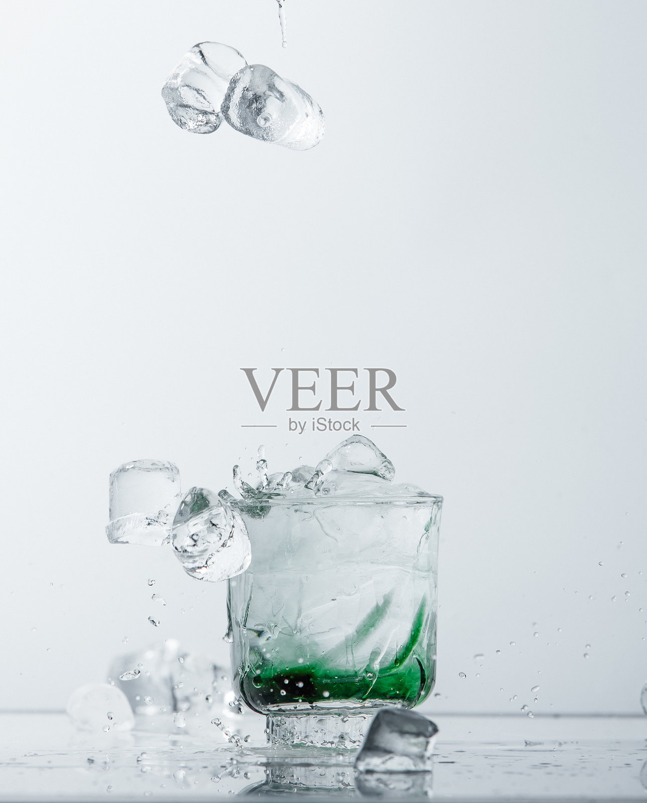 清爽的鸡尾酒与落下的冰块照片摄影图片