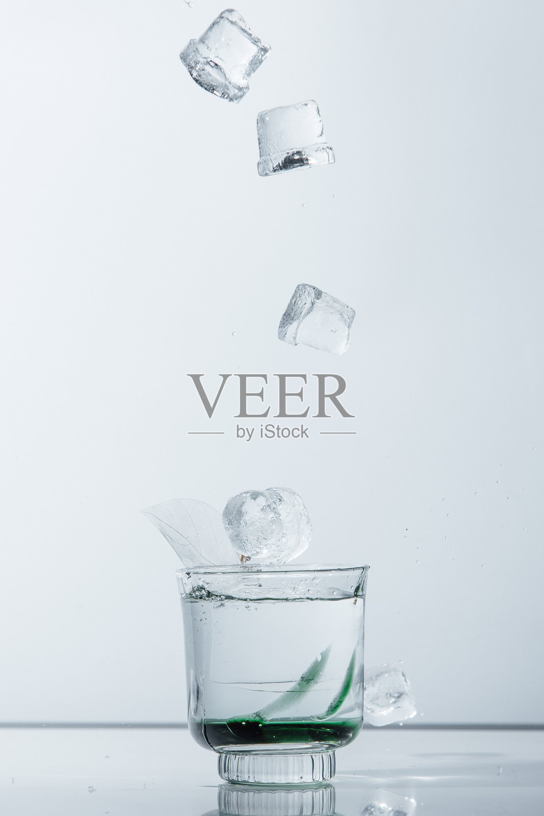 清爽的鸡尾酒与落下的冰块照片摄影图片