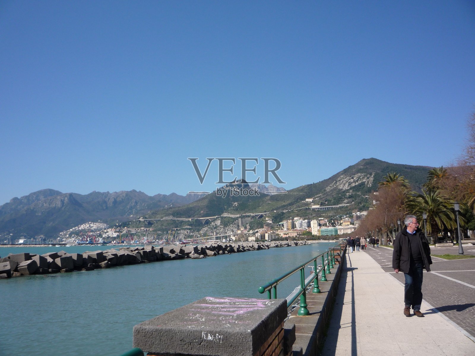 人们在意大利萨勒诺的海滨散步。照片摄影图片