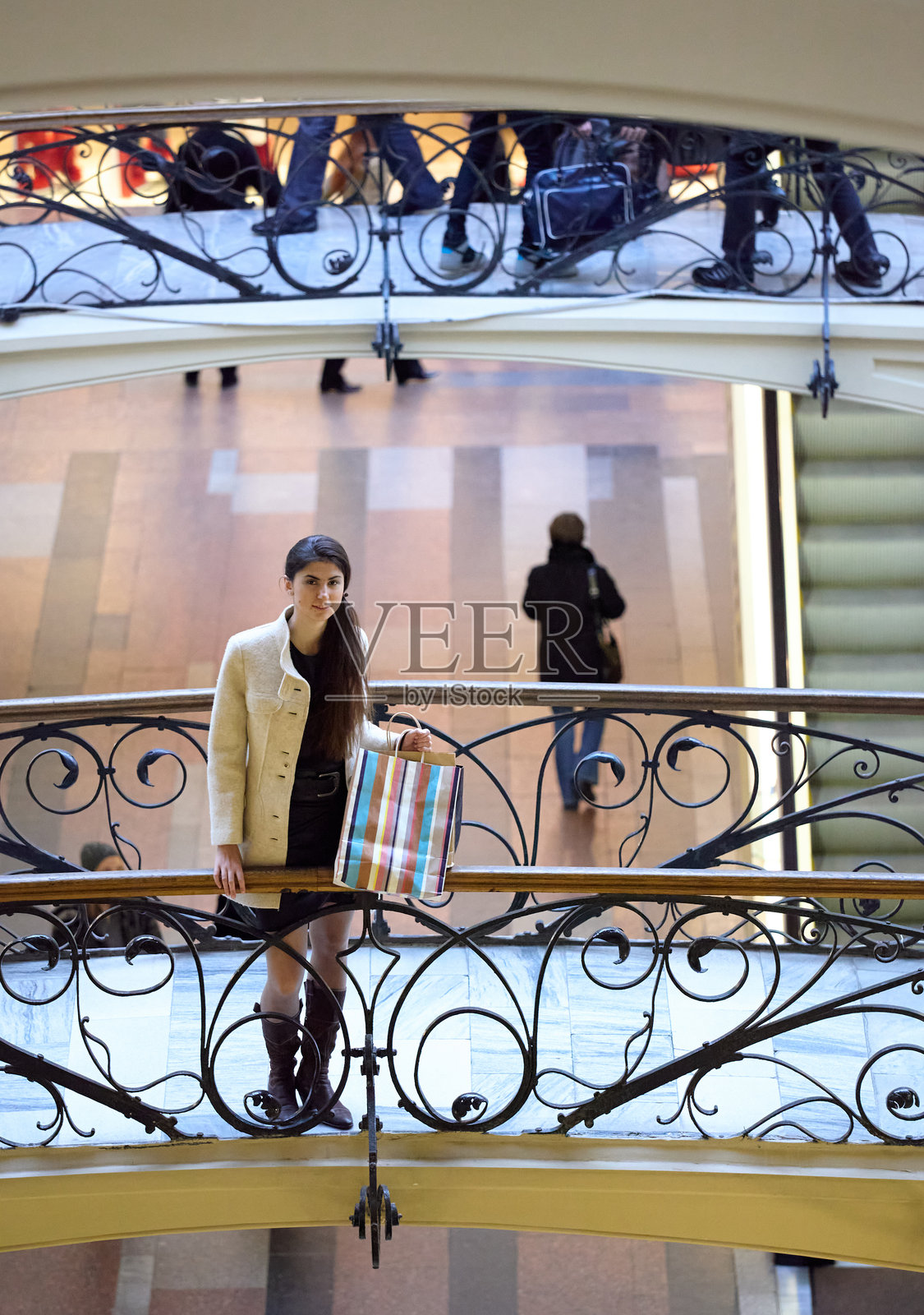 年轻时尚女性在购物中心手提购物袋站立照片摄影图片