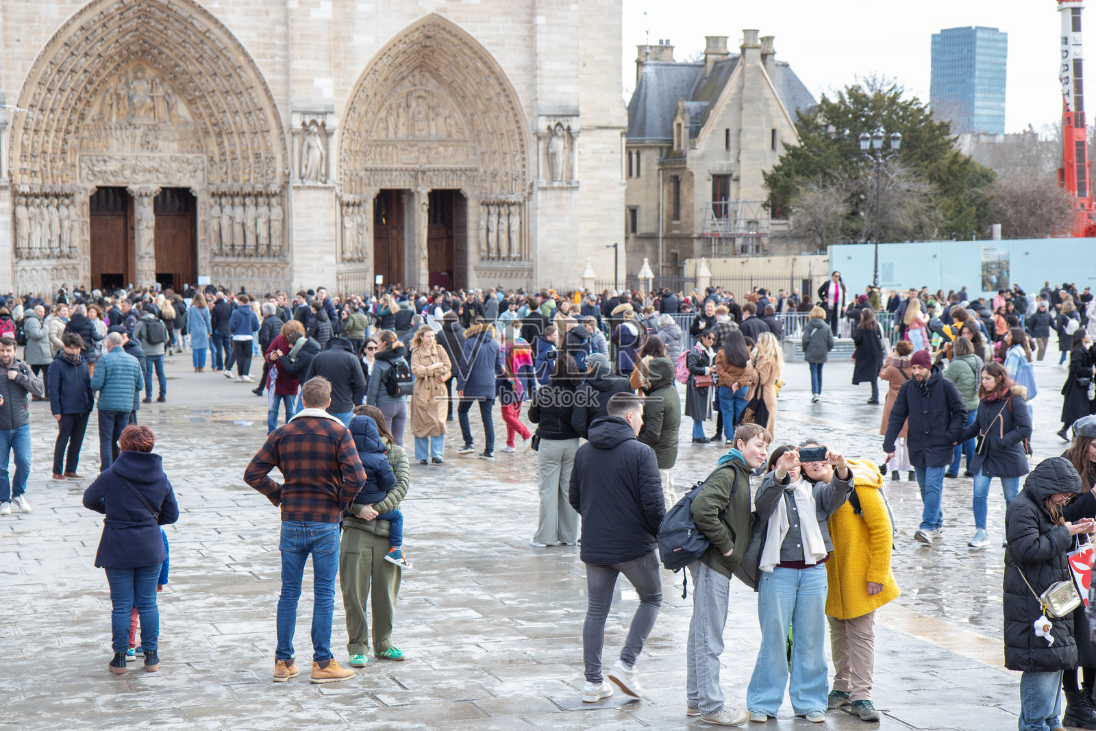 法国巴黎 - 2025年2月22日：巴黎圣母院和在重建后重新开放的教堂前的游客照片摄影图片