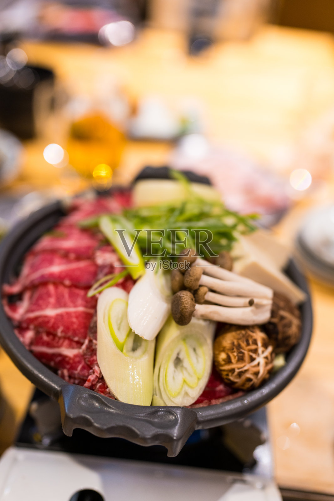 日本寿喜烧火锅，配有蔬菜和牛肉片照片摄影图片