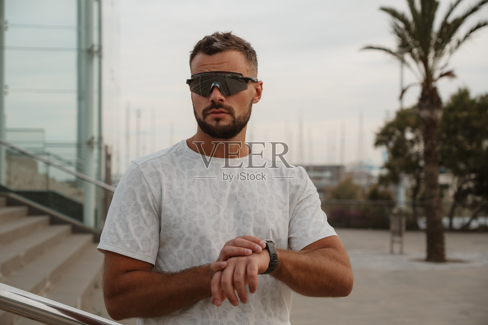 运动员戴着未来感太阳镜查看智能手表上的时间照片摄影图片