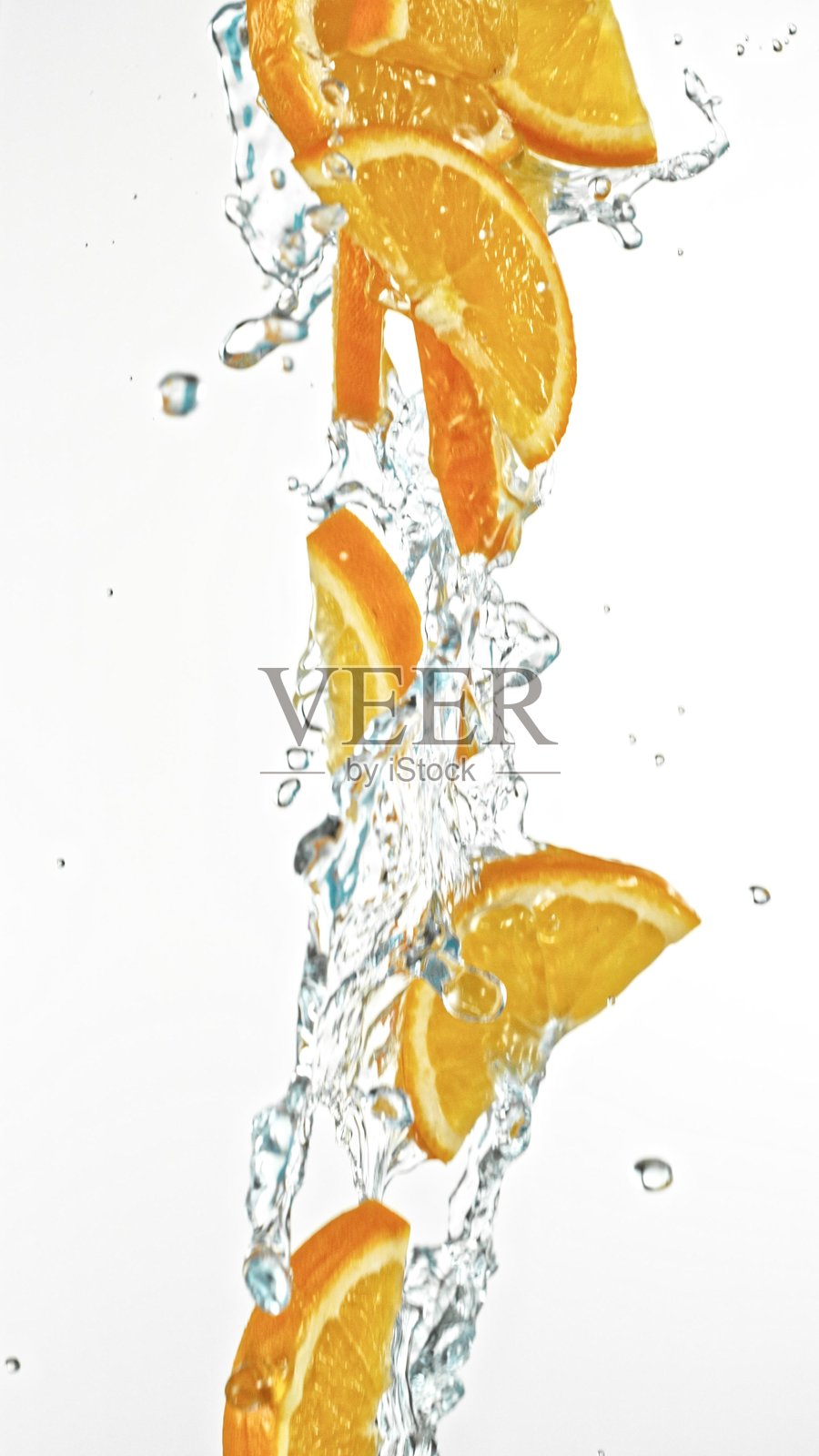 新鲜橙子片在水花中落下，背景为白色。照片摄影图片