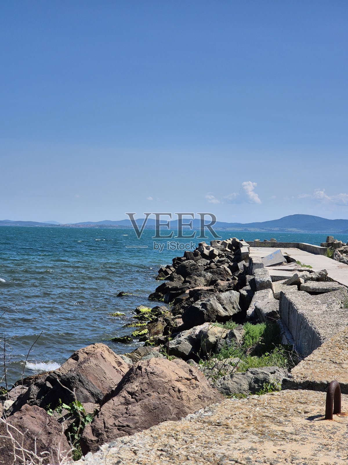 延伸入海的防波堤。混凝土码头，海中的岩石脊。照片摄影图片