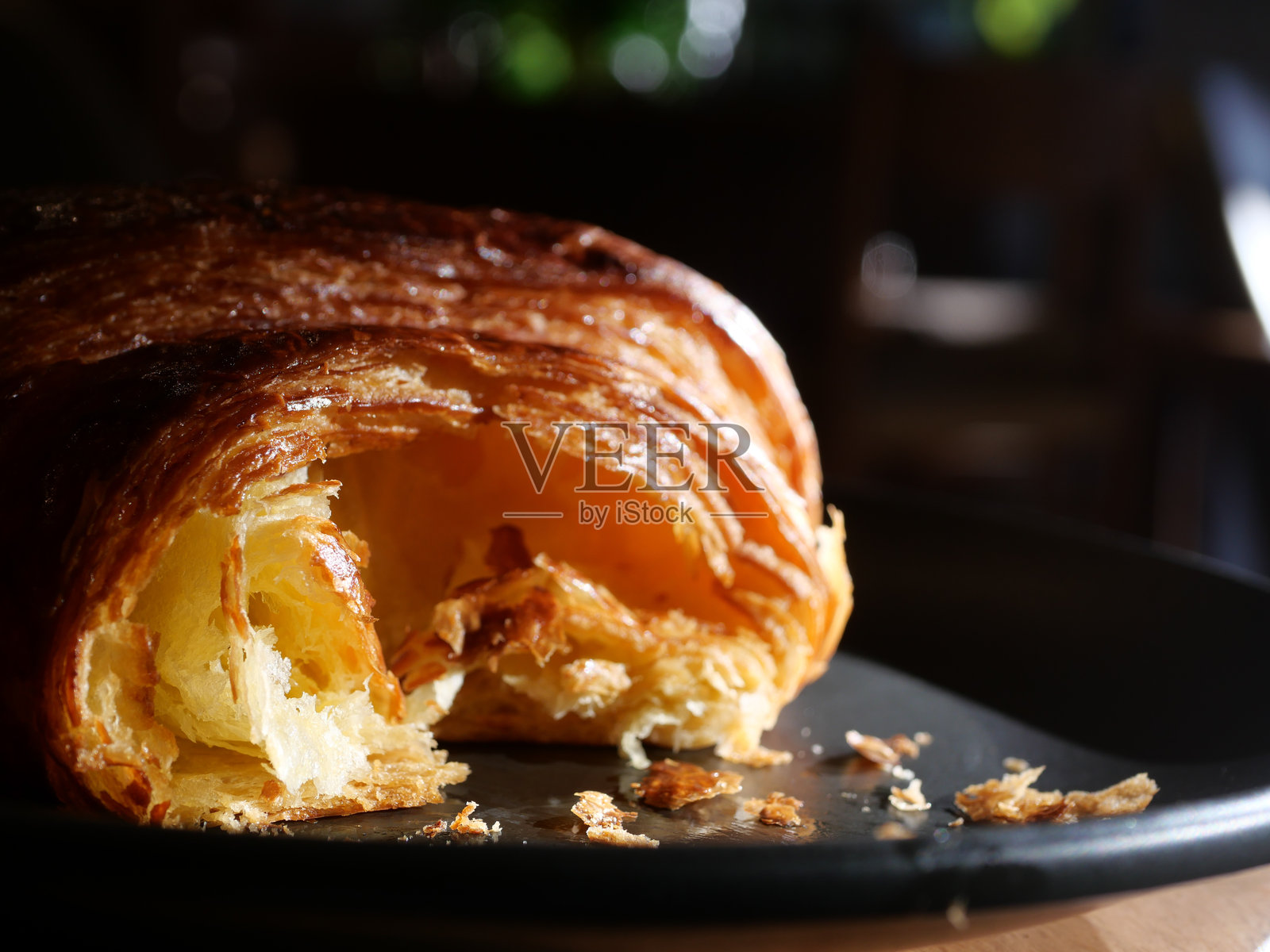 温馨咖啡馆环境中的新鲜出炉的可颂面包放在盘子里照片摄影图片