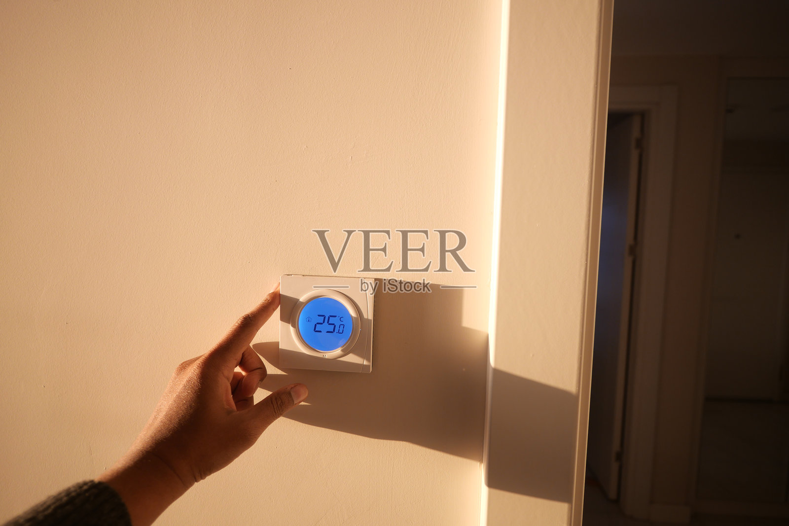 在明亮的房间里调节恒温器的温度照片摄影图片