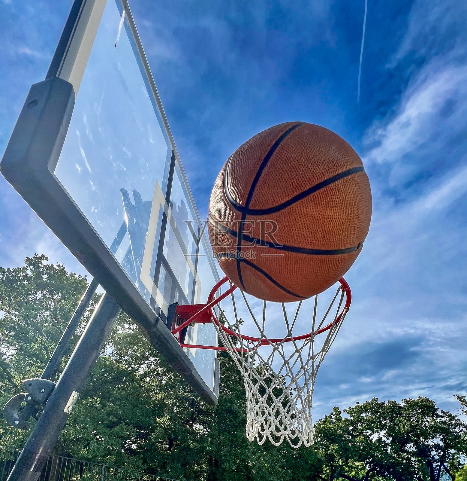 阳光明媚的日子里，篮球被投进篮筐 – 户外运动动态镜头照片摄影图片