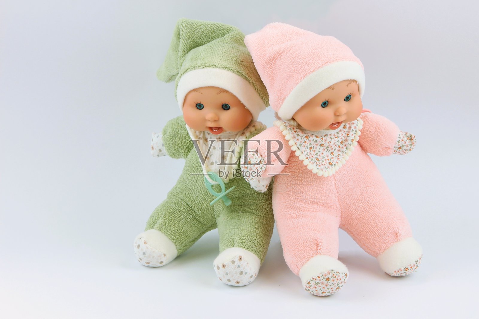 可爱的绿色和粉色睡衣毛绒婴儿娃娃照片摄影图片