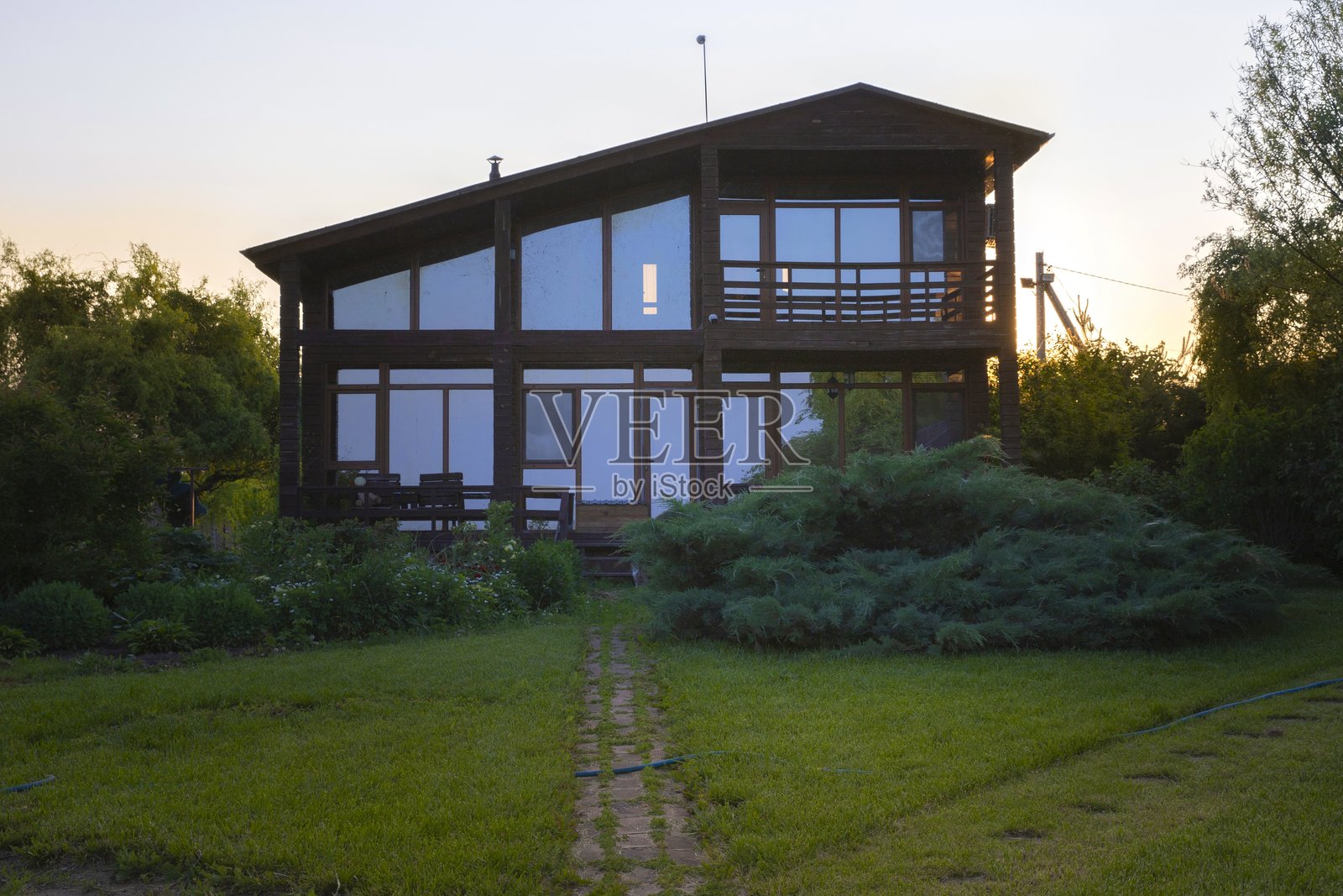现代木屋与花园在日落时分，宁静的乡村生活方式照片摄影图片