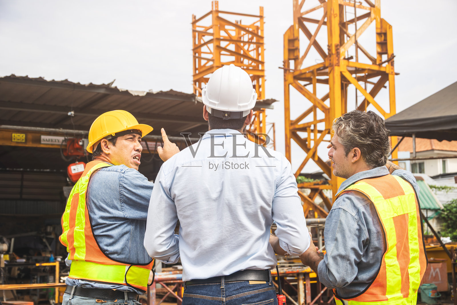 建筑工程师团队在工地上共同合作，交流讨论。照片摄影图片