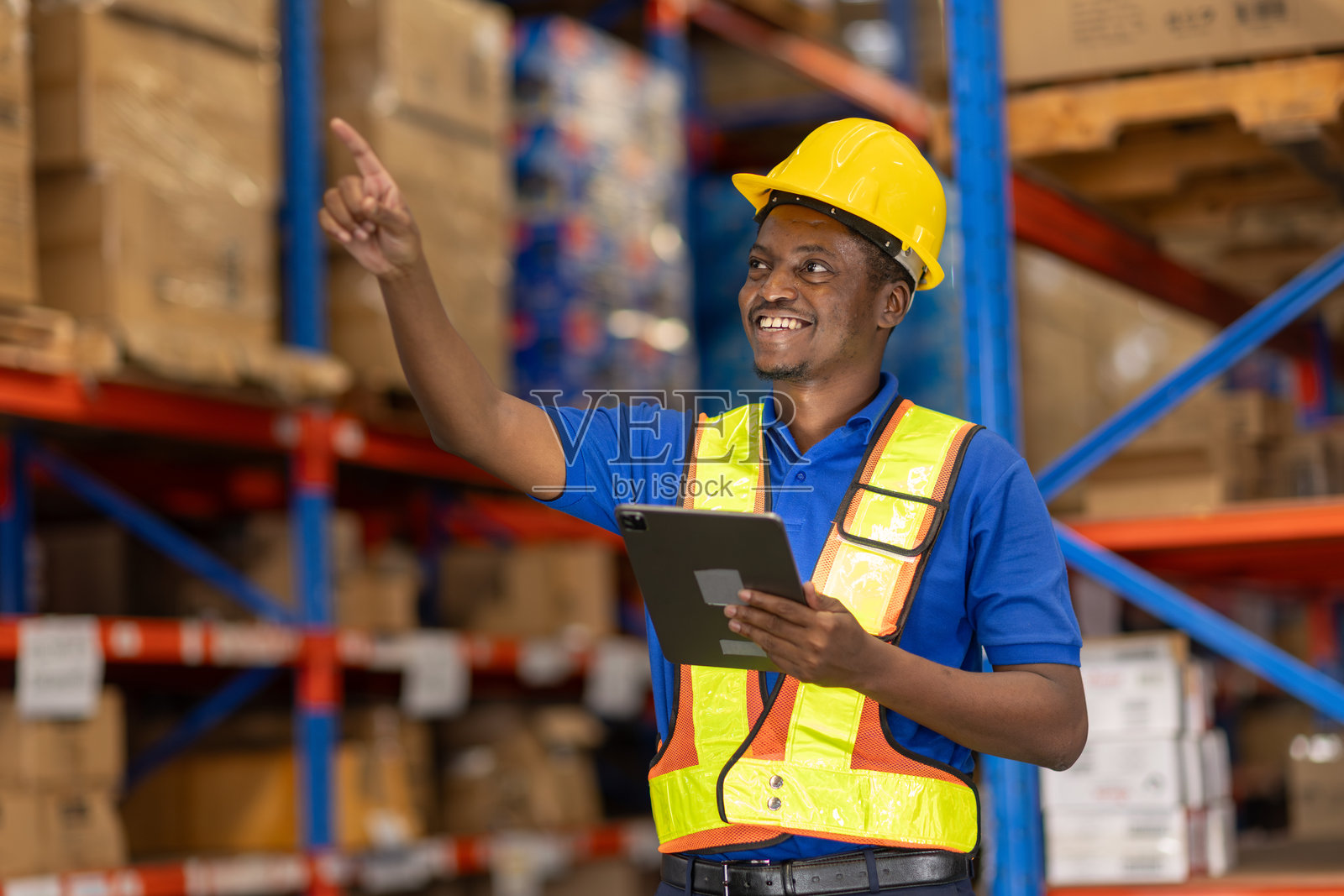 非裔美国男性在仓库中使用平板电脑进行库存检查，正在数货架上的库存。照片摄影图片